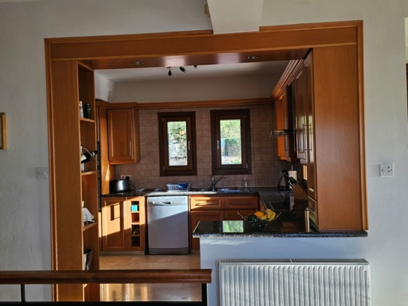 Hauson Realty - Cyprus Real Estate Agents A kitchen with wooden cabinets and a wooden floor.