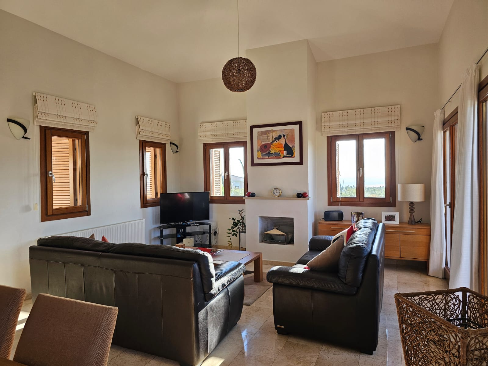 Hauson Realty - Cyprus Real Estate Agents A living room with a fireplace and large windows.